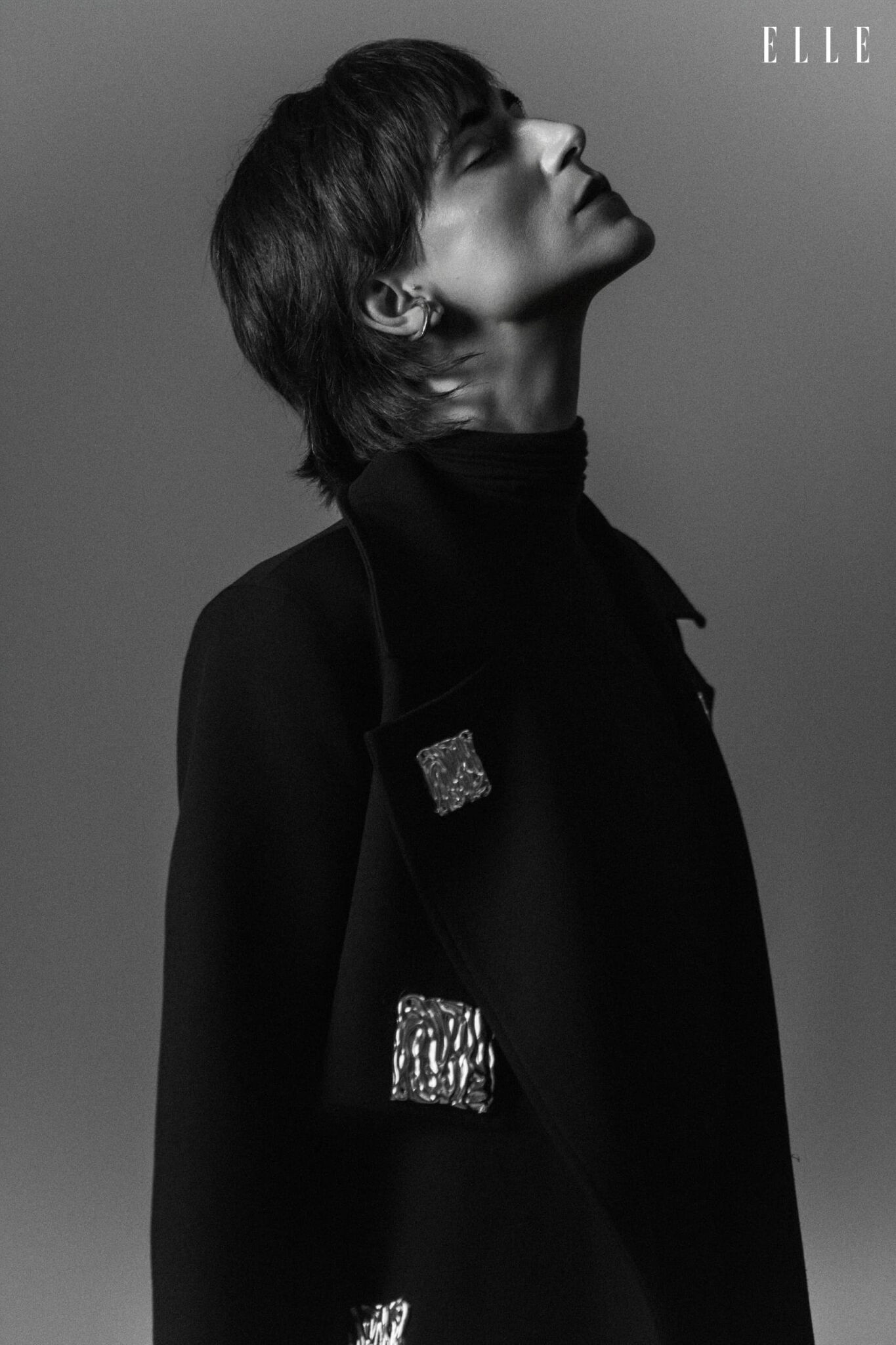 Daiane Conterato in profile, wearing a dark coat and a high-neck blouse.