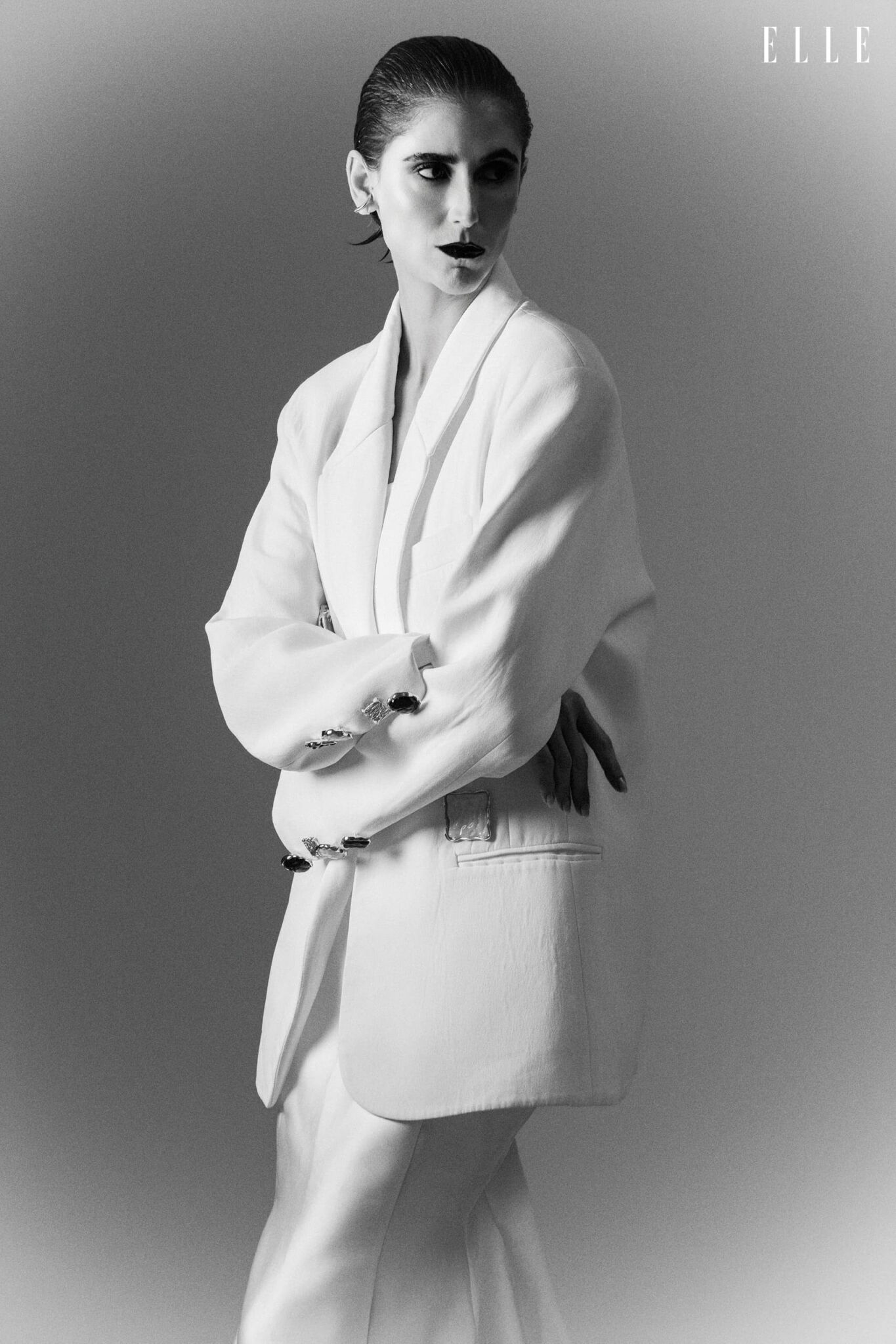Daiane Conterato wearing a light blazer over a long dress.