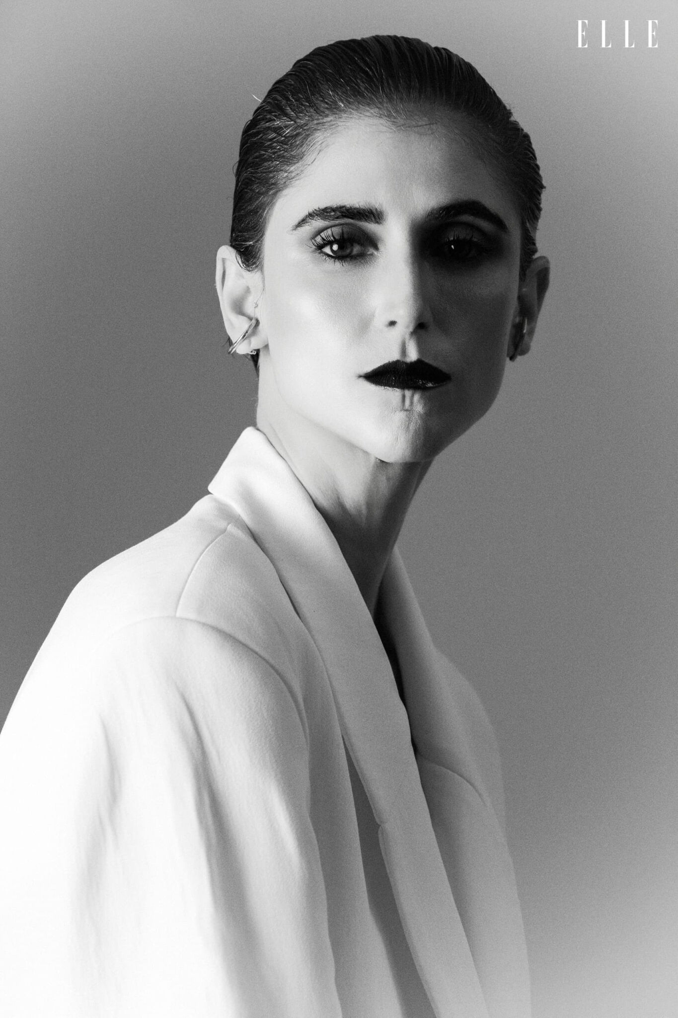 Close-up portrait of Daiane Conterato in a light blazer and dark lipstick.