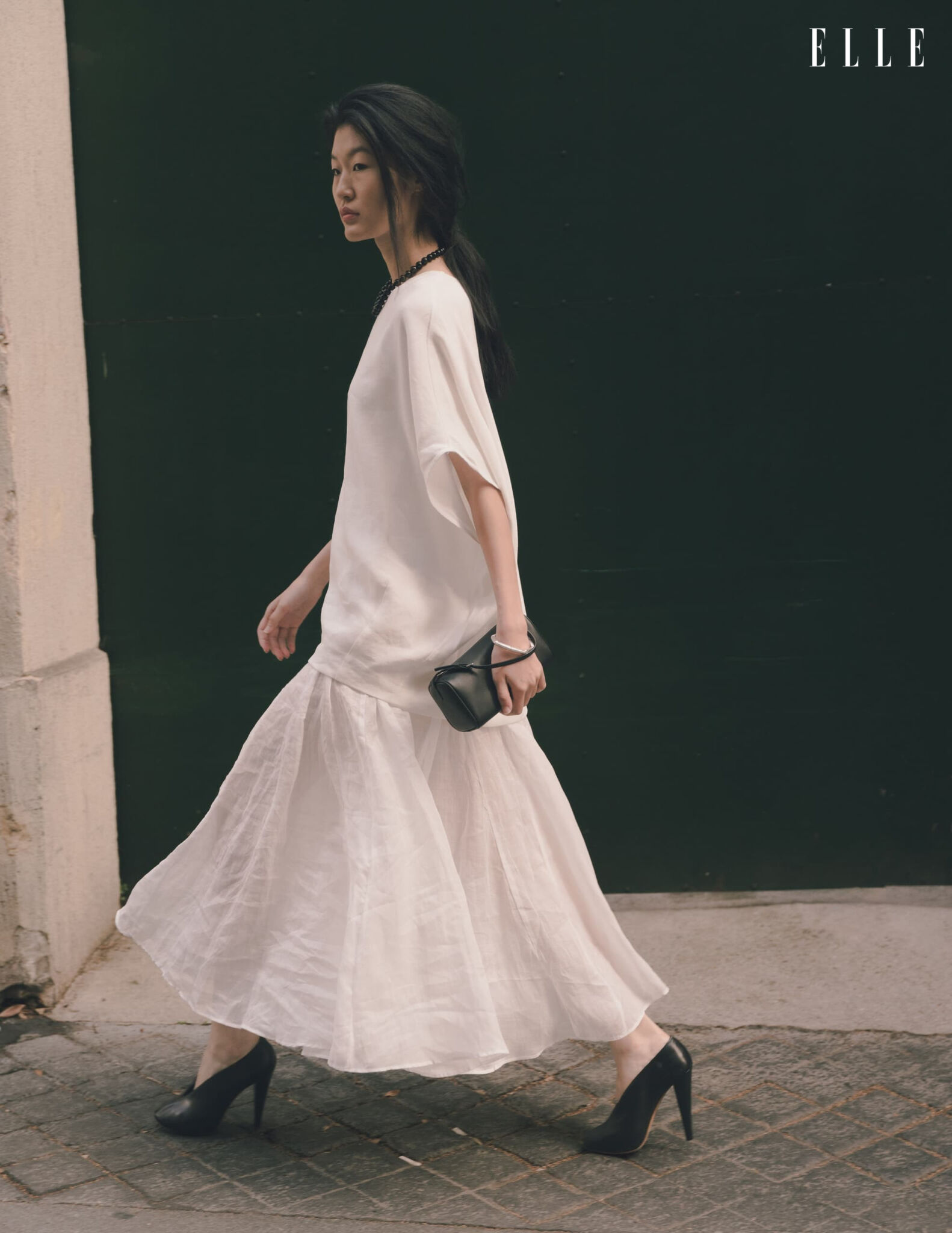 Qian Wen Wu in a flowing white dress on a Paris street
