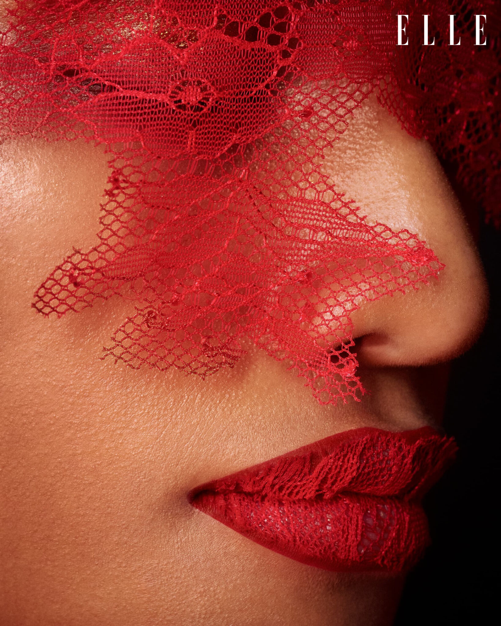 Close-up of red lips and lace across the face