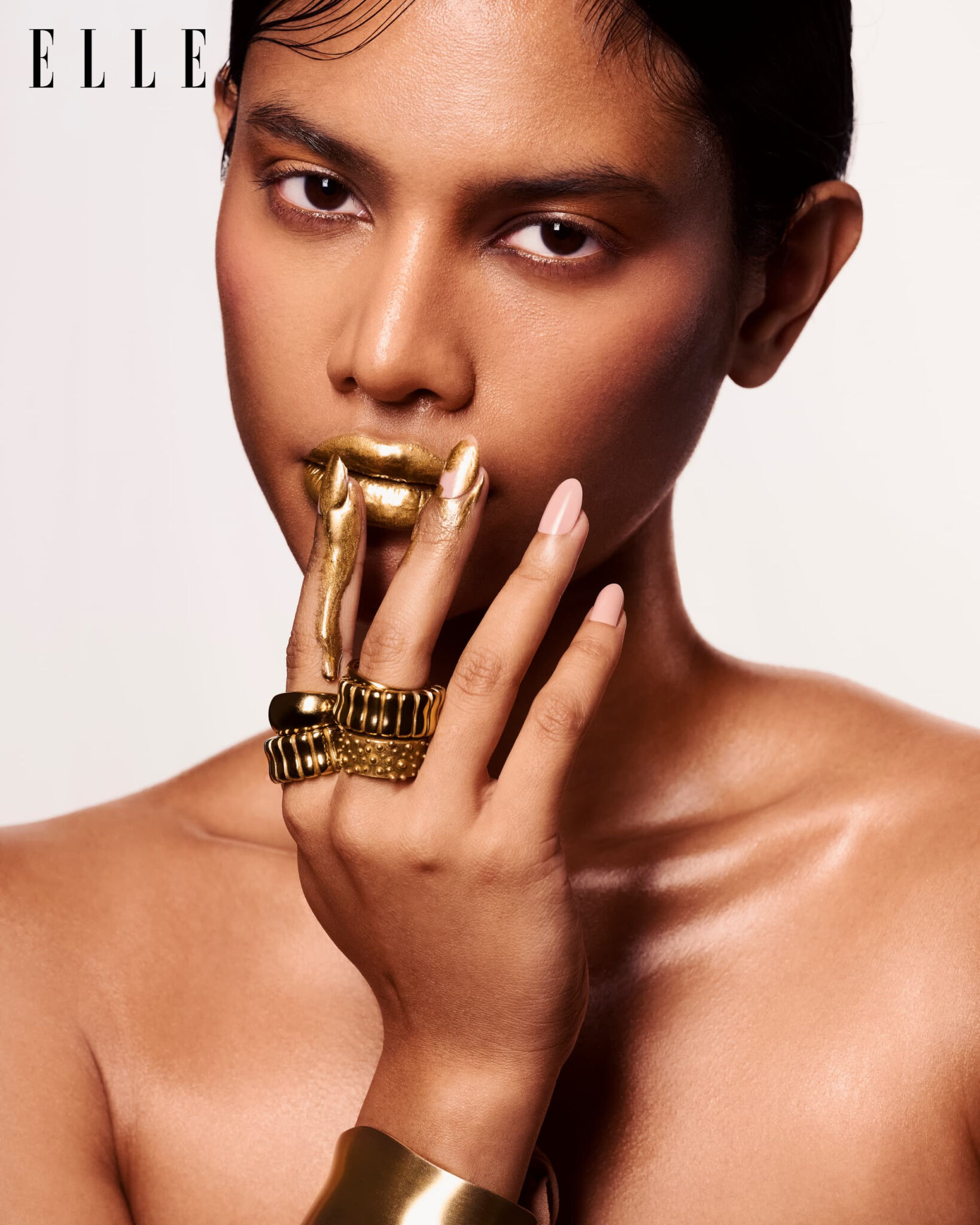 Beauty portrait with gold lips, metallic fingers and jewelry