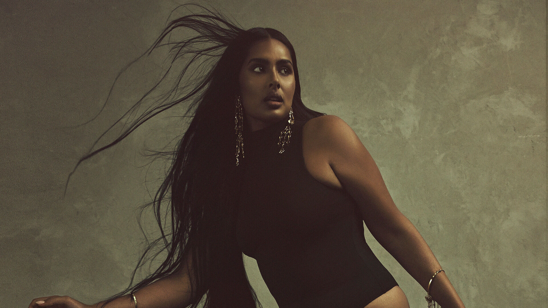Shanaya Peters in a black Skims bodysuit and cascading jewellery, photographed by Bernard Guéit.