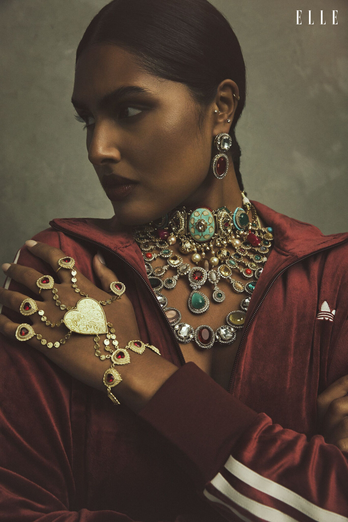 Shanaya Peters in a burgundy adidas top with layered necklaces and hand jewellery.