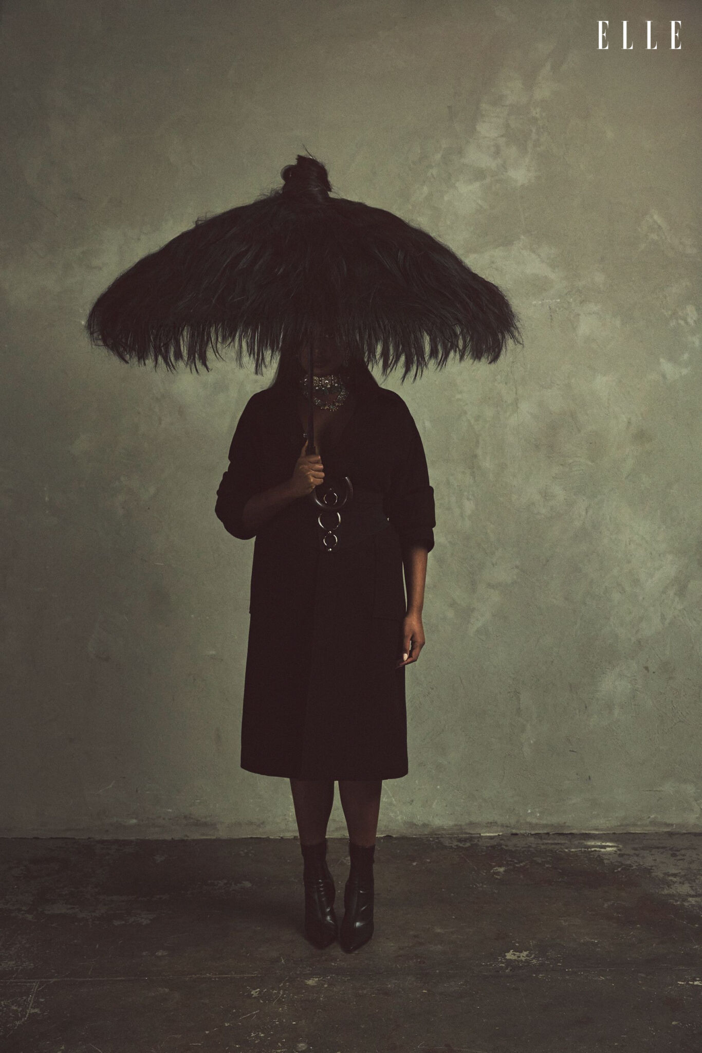 Shanaya Peters in a dark coat beneath a custom-made hair umbrella.